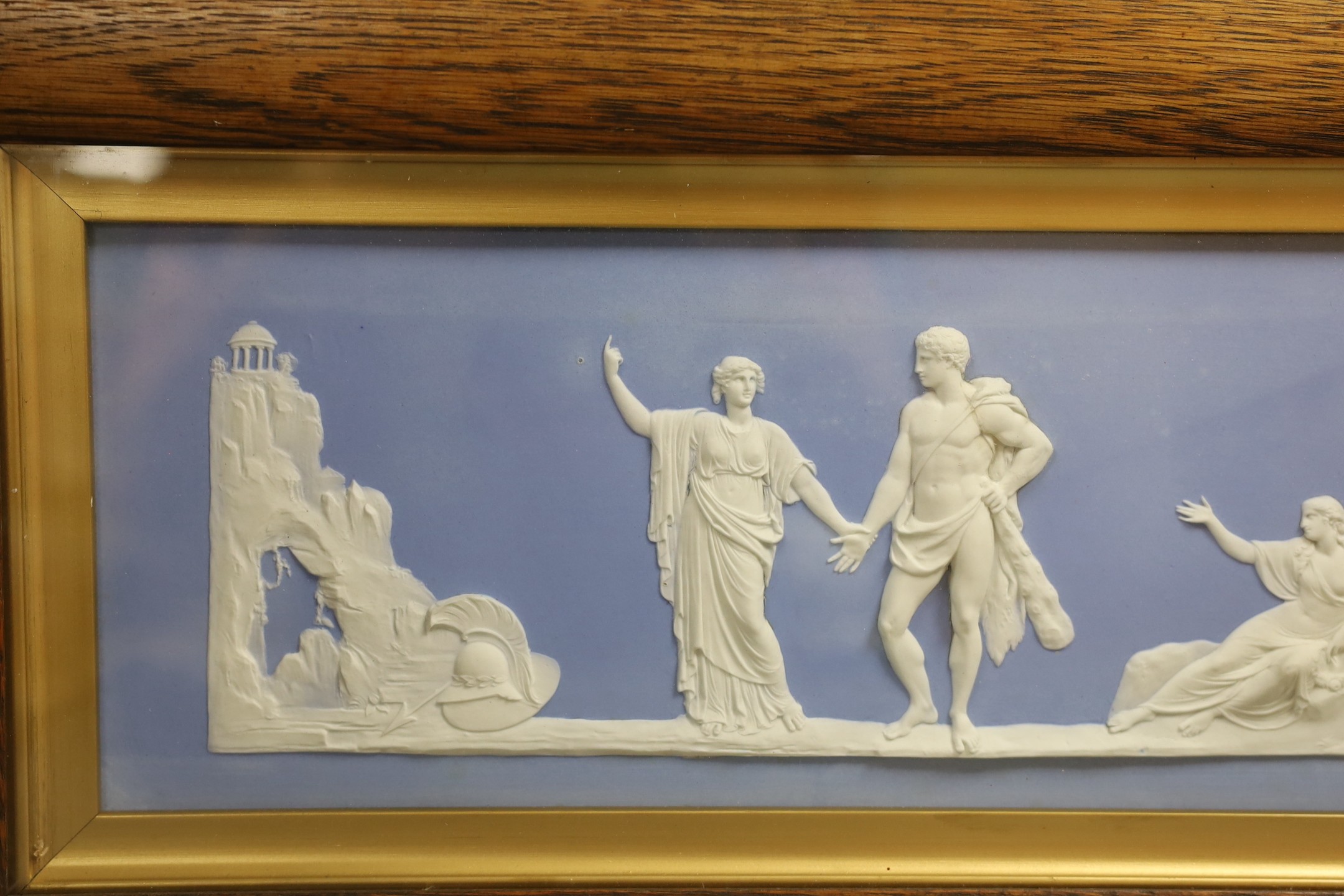 A large Wedgwood blue jasper plaque, early 20th century, impressed mark Wedgwood England, plaque 44 cm X 14 cm, framed and glazed